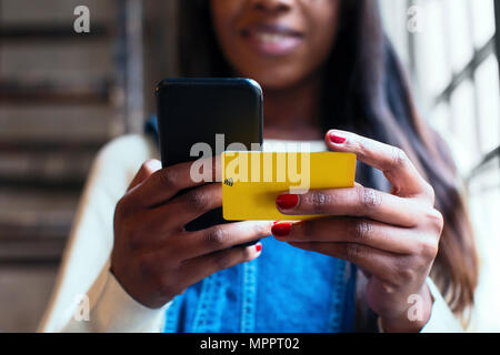Woman's hands holding cell phone and wifi keycard, close-up Stock Photo