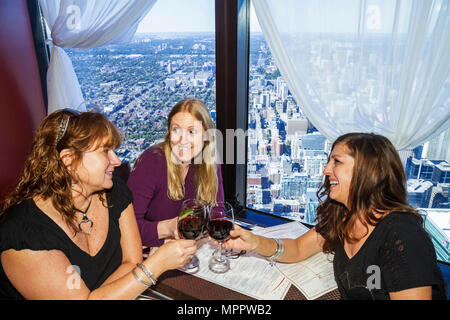 Toronto Canada,CN Tower,observation main deck level,Horizons Cafe,restaurant dining women drinking,wine friends toasting visitors Stock Photo