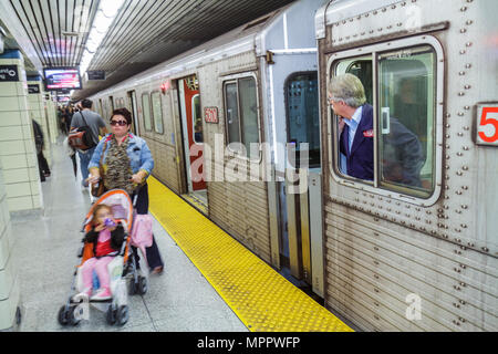 Toronto Canada,College Station,Yonge Yellow Line,TTC,Transit Commussion subway train,man male woman,girl mother child stroller conductor platform Stock Photo