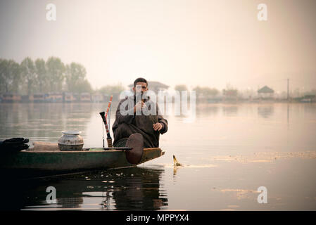 Man sitting on shikara ready for fishing in srinagar, dal lake Stock Photo