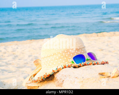 hat and sunglasses on the beach with sea  backround, Concept of summer traveling Stock Photo