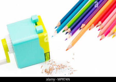 pastel blue yellow rotary pencil sharpener shavings with wooden colorful pencils isolated on white background, back to school education concept Stock Photo
