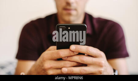 Close up of man working on mobile phone. Man operating mobile phone with two hands. Stock Photo