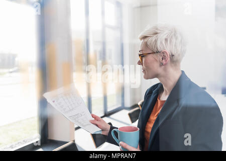 Businesswoman reading document in office Stock Photo