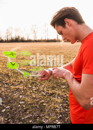 Sportive young man having a break checking data emerging from smartwatch Stock Photo