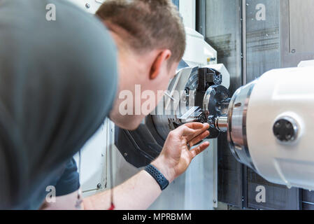 Man working at machine in factory Stock Photo