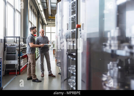 Two men standing in modern factory Stock Photo