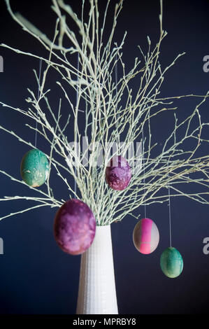 Sprayed twigs with dyed Easter eggs Stock Photo