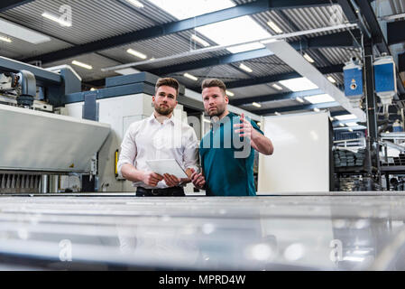 Two men with tablet discussing on factory shop floor Stock Photo