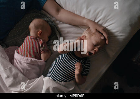 Vater lying next to his daughter and son in bed Stock Photo