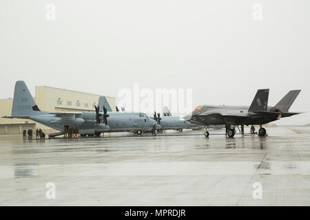 A U.S. Marine Corps F-35B Lightning II aircraft with Marine Fighter Attack Squadron (VMFA) 121 refuels using a KC-130J Hercules with Marine Aerial Refueler Transport Squadron (VMGR) 152 during aviation delivered ground refueling training at Marine Corps Air Station Iwakuni, Japan, April 11, 2017. The ADGR marked the first evolution of this form of refueling for VMFA-121’s F-35B Lightning II aircraft, and it increases the squadron’s ability to refuel by C-130 aircraft in austere locations when other resources may not be available. Stock Photo