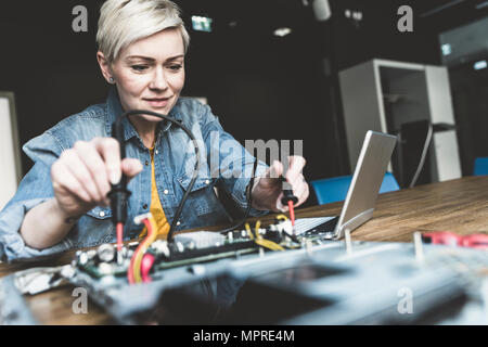 Woman working on computer equipment Stock Photo