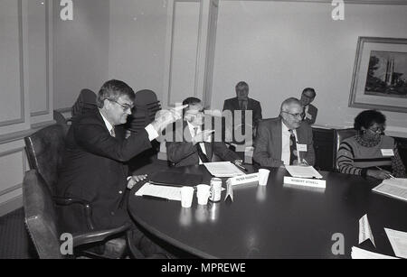 United States Agency for International Development (USAID) is an independent U.S. government agency tasked with administering foreign economic and humanitarian assistance since 1961. Men and a woman are engaged in conversation associated with the agency’s professional activities. The historical photographic print records interaction among personnel connected to USAID. Stock Photo