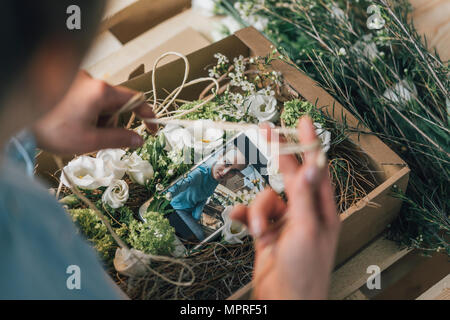 Woman arranging present in a box, partial view Stock Photo