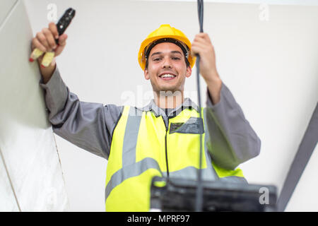 Portrait of smiling electrician on construction site Stock Photo