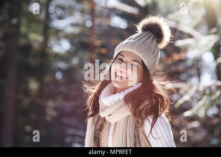 Portrait of laughing young woman wearing knitwear in winter forest Stock Photo