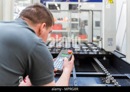 Man operating machine in factory Stock Photo