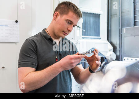 Man examining workpiece in factory Stock Photo