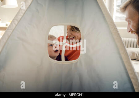 Happy family playing in a tent at home Stock Photo