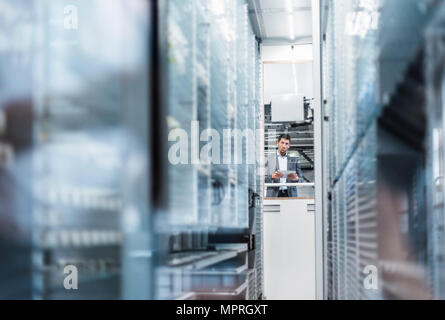 Businessman with tablet in modern factory Stock Photo