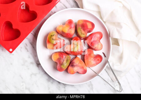 Homemade heart-shaped ice cubes on plate Stock Photo