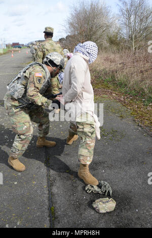 U.S. Army Sgt. Joel Delarosa assigned to 39th Signal Battalion, immobilizes and searches the suspect during the Entry Control Point Searching Vehicle Commander exercise, in Chièvres Air Base, Belgium, March 21, 2017. (U.S. Army photo by Visual Information Specialist Pascal Demeuldre) Stock Photo