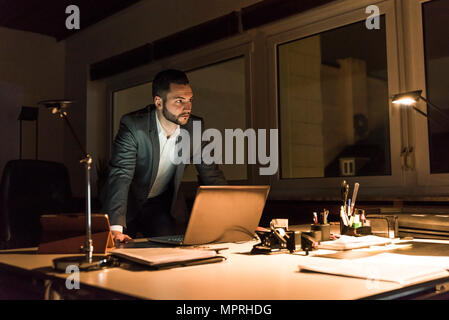 Businessman working in office at night Stock Photo