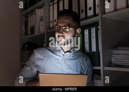 Portrait of businessman with tablet working late in office Stock Photo