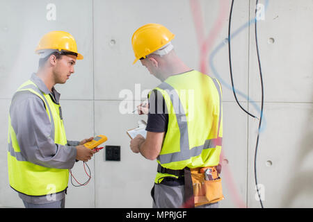 Electricians working on construction site Stock Photo