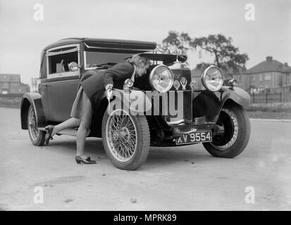 Kitty Brunell looking under the bonnet of a Talbot 14/45 sportsman's coupe, c1928. Artist: Bill Brunell. Stock Photo