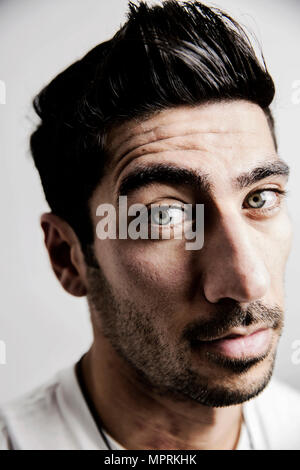 Portrait of sceptical young man raising his eyebrow Stock Photo