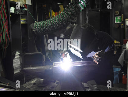 YOKOSUKA, Japan (April 11, 2017) - Hull Maintenance Technician 3rd Class Thomas Dwyer, from Florham Park, New Jersey, attached to the U.S. 7th Fleet flagship USS Blue Ridge (LCC 19), welds an anvil. Blue Ridge is in an extensive maintenance period in order to modernize the ship to continue to serve as a robust communications platform in the U.S. 7th Fleet area of operations. Stock Photo