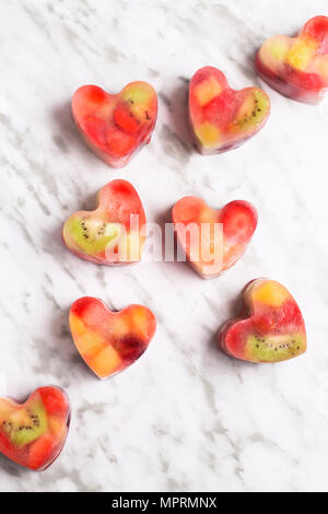 Homemade heart-shaped ice cubes on marble Stock Photo