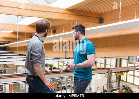 Two men with tablet in modern factory looking at shop floor Stock Photo
