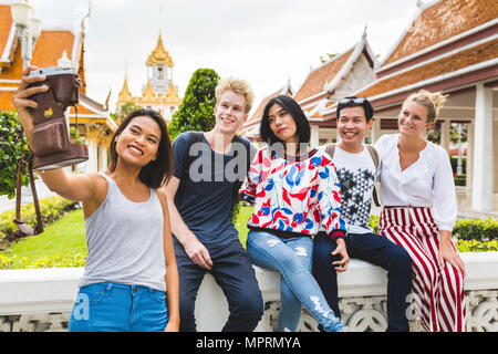 Thailand, Bangkok, five friends taking selfie with smartphone in front of temple complex Stock Photo