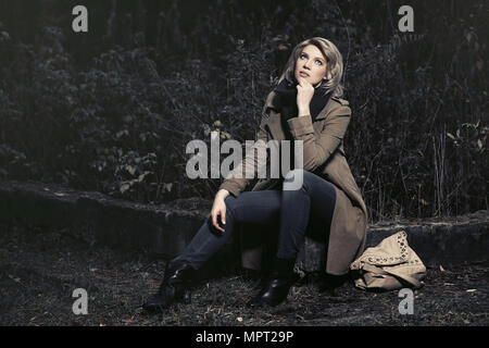 Young fashion blond woman in classic beige coat outdoor Stock Photo