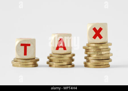 The word Tax written with wood blocks on top of coins piles - Tax increase concept Stock Photo