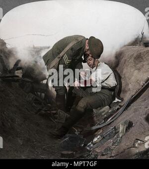 Soldier receiving first aid from a sergeant in a sap, Battle of Peronne, World War I, 1914-1918. Artist: Realistic Travels Publishers. Stock Photo