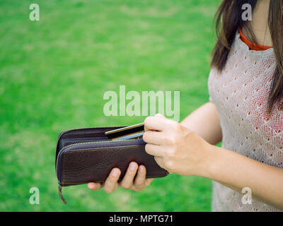 Closeup woman hand putting credit card into leather wallet . Business and financial, money saving concept. Stock Photo
