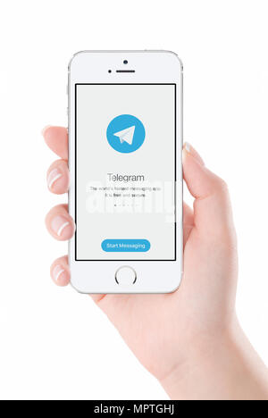 Telegram messenger launch screen on iPhone smartphone display in female hand. Stock Photo
