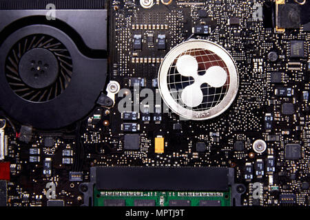A Ripple physical coin sitting on a computer motherboard with a fan and RAM. real-time gross settlement system, exchange and remittance network Stock Photo