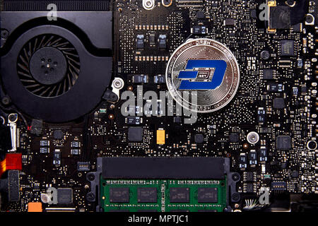 An Dash Coin physical coin sitting on a computer motherboard with a fan and RAM. Dash coin is meant to be very user friendly Stock Photo