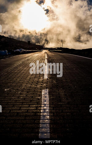 horror scared scene with dark straight road and clouds like a fire event. ground point fo view and white line in the middle. Stock Photo