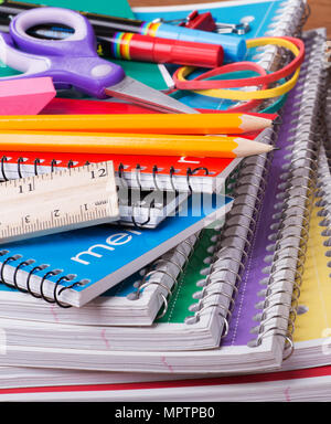 Closeup of an assortment of school supplies on top of a stack of spiral notebooks Stock Photo