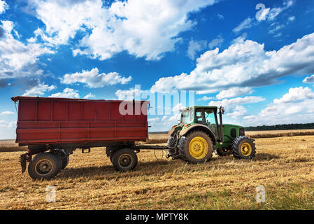 Dobrich, Bulgaria - July 08: Modern John Deere tractor in the field near the town Dobrich, Green tractor on the agricultural field on sunny summer day Stock Photo