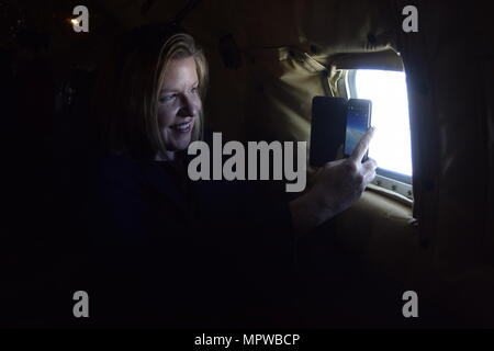 Debra Toufel, University of Oklahoma Price College of Business director of public private partnerships, and member of the Tinker Air Force Base Honorary Commander's 2017 Class takes a photo through the fuselage window of a KC-135R Stratotanker during a local training flight April 6, 2017, from Tinker Air Force Base, Oklahoma. The Honorary Commander's learned about the mission of the 507th Air Refueling Wing, Air Force Reserve Command, during an air refueling mission with F-16 Fighting Falcons of the 138th Fighter Wing, Oklahoma Air National Guard. (U.S. Air Force photo/Greg L. Davis) Stock Photo