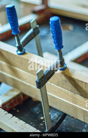 Joinery. Gluing and clamping wooden planks. Wooden edge-glued panels. Close-up Stock Photo