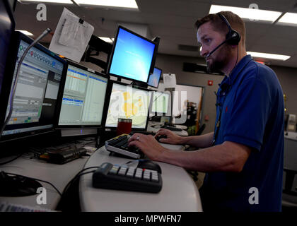 170412-N-PP197-015 JACKSONVILLE, Fla. (April 12, 2017) Jason Solomon, a Navy Region Southeast 911 emergency dispatcher, works at his multiscreen station in the Navy Region Southeast Regional Dispatch Center. The RDC currently dispatches fire and security personnel for 14 installations. (U.S. Navy photo by Mass Communication Specialist 1st Class Stacy D. Laseter/Released) Stock Photo