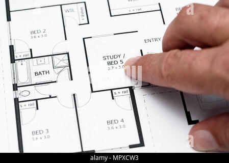 Mans finger pointing to house plans / diagram Stock Photo