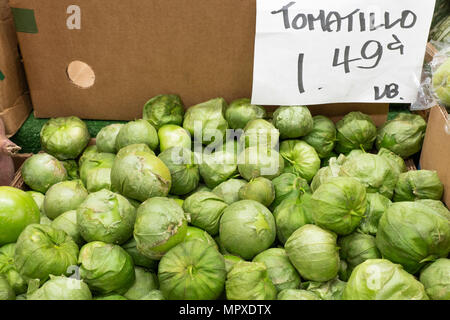 Pile of Green Tomatillos for sale at the market with sign saying 1.49 lb Stock Photo
